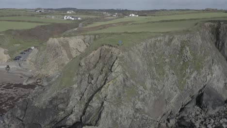 Aerial-retreats-from-drone-pilot-on-rugged-rock-cliffs,-rural-Ireland