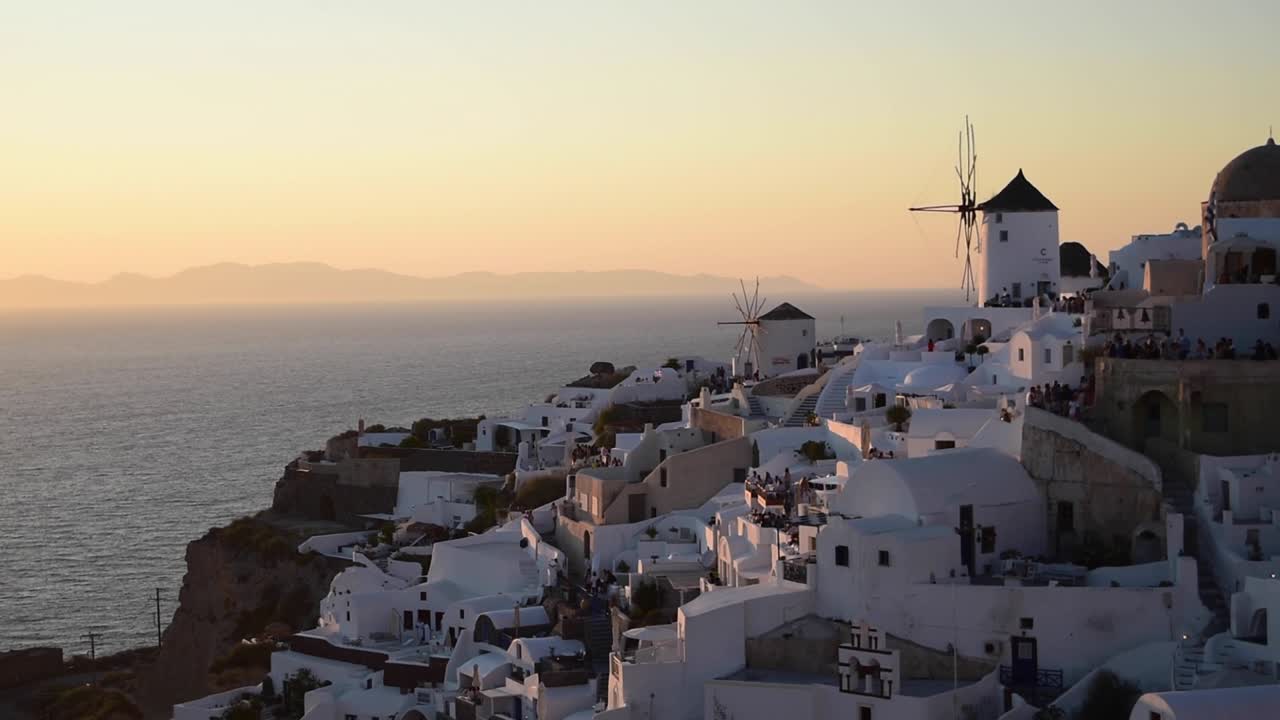 el hermoso pueblo de oia lleno de turistas para la puesta de sol, isla de santorini, grecia