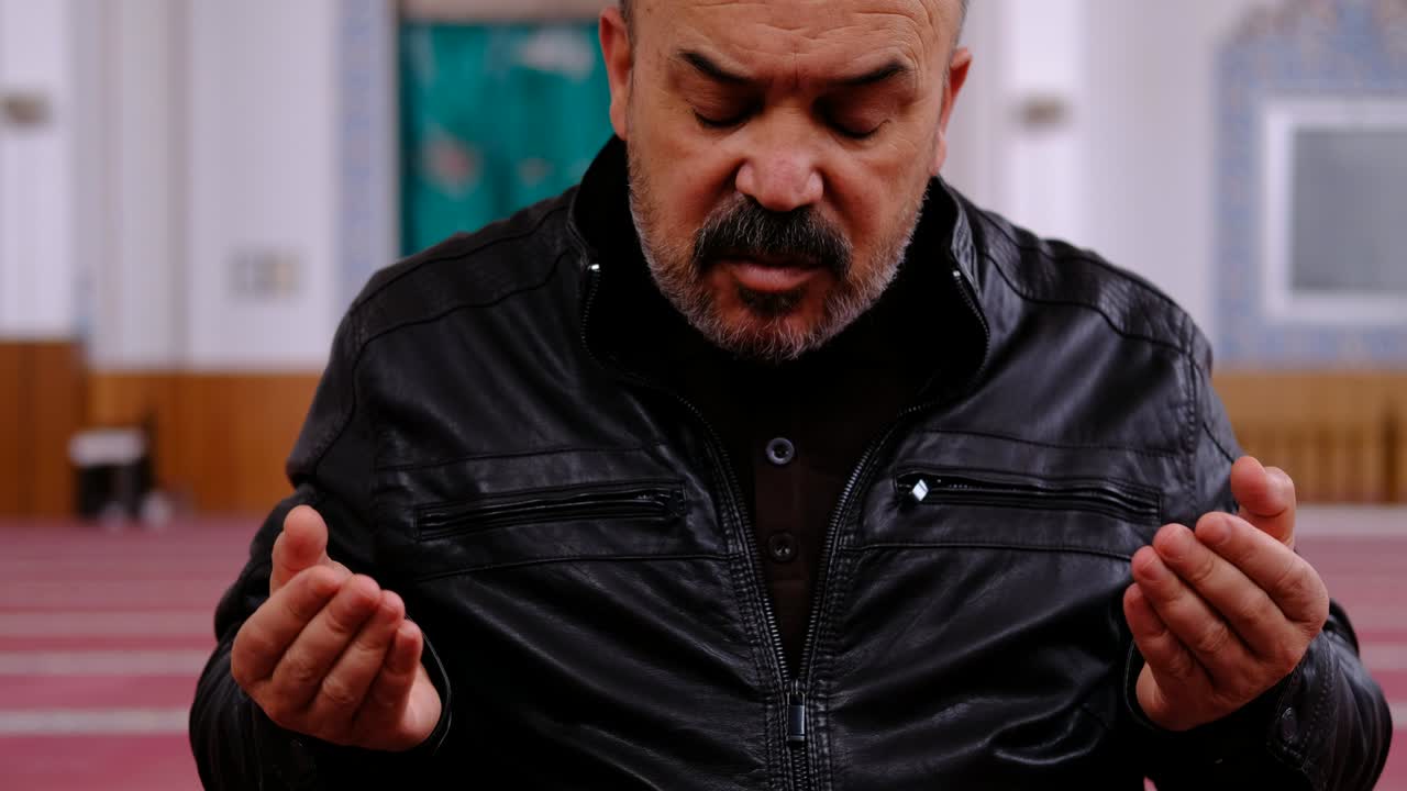 hombre levantando las manos orando en la mezquita