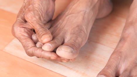 close-up of elderly person's wrinkled feet and hands