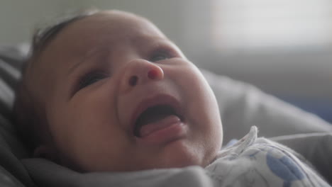 primer plano de un bebé llorando en una silla alta