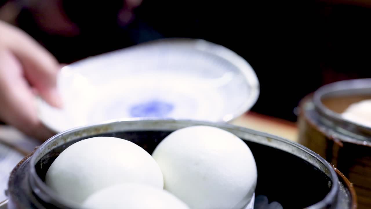 Opening steamer to reveal fresh dumplings