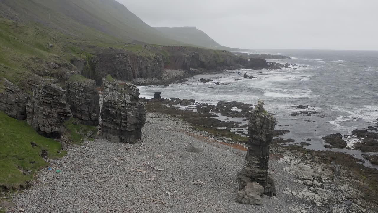 rocas en la escarpada costa islandesa con las olas del océano salpicando