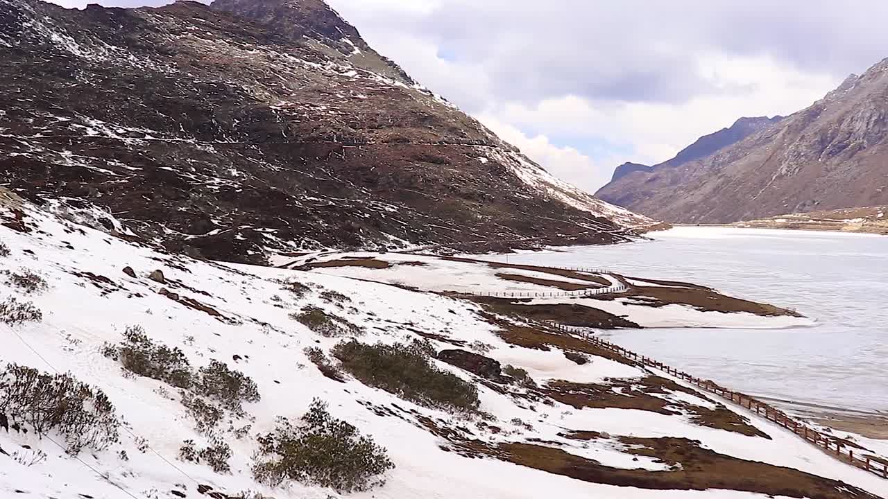 lago sela congelado con montañas cubiertas de nieve y cielo azul brillante por la mañana desde un video de ángulo plano tomado en sela tawang arunachal pradesh india