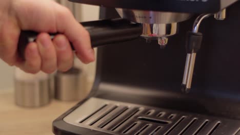 Inserting-freshly-grinded-coffee-beans-inside-portafilter-into-machine