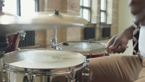 close up of african american musician playing drumkit