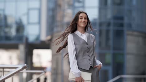 stylish young woman in a business suit with a vest and handbag spinning and posing modelly