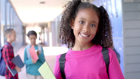 in a school hallway, a young african american student smiles brightly