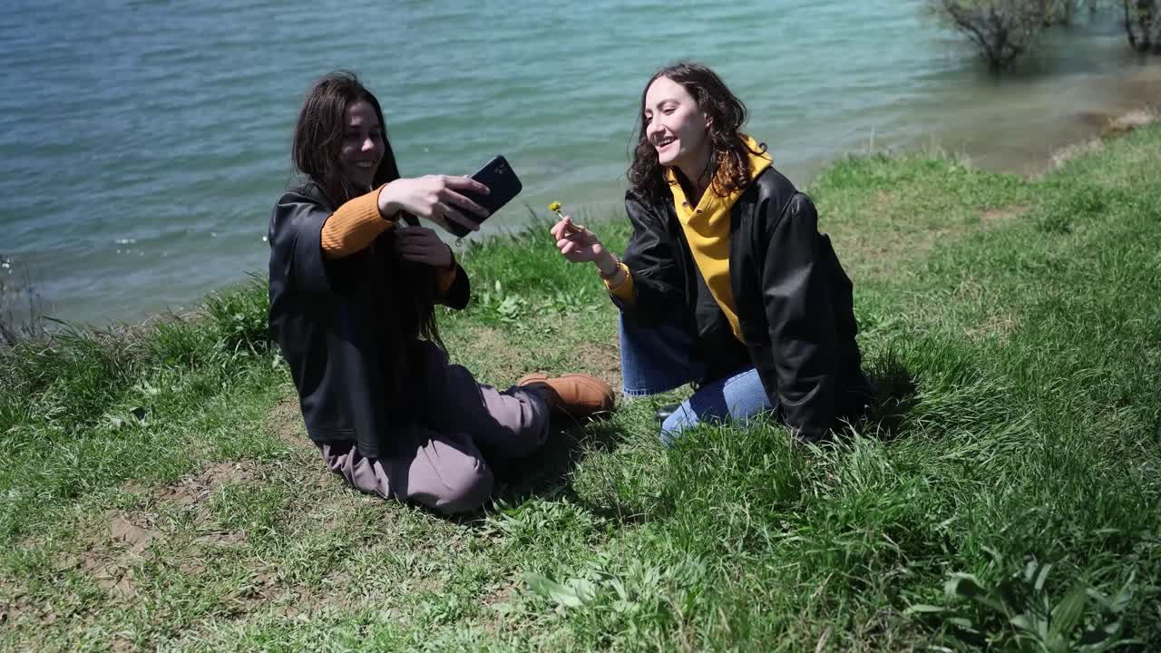 Two women taking a selfie by the lake