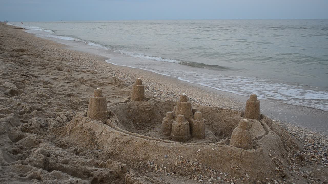 Fortaleza de areia na praia. Filmagem no verão.