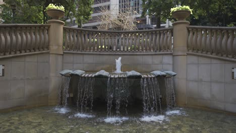 slow motion shot of a fountain in a city during the day