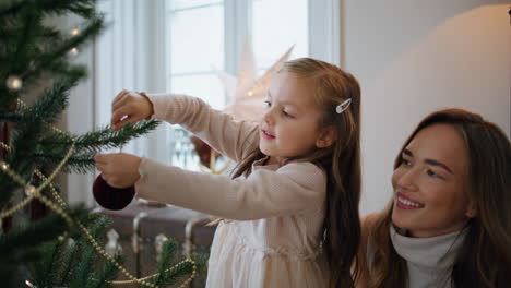 Süße-Frau-Und-Kind-Schmücken-Weihnachtsbaum-Zu-Hause,-Nahaufnahme.-Mutter-Umarmt-Tochter