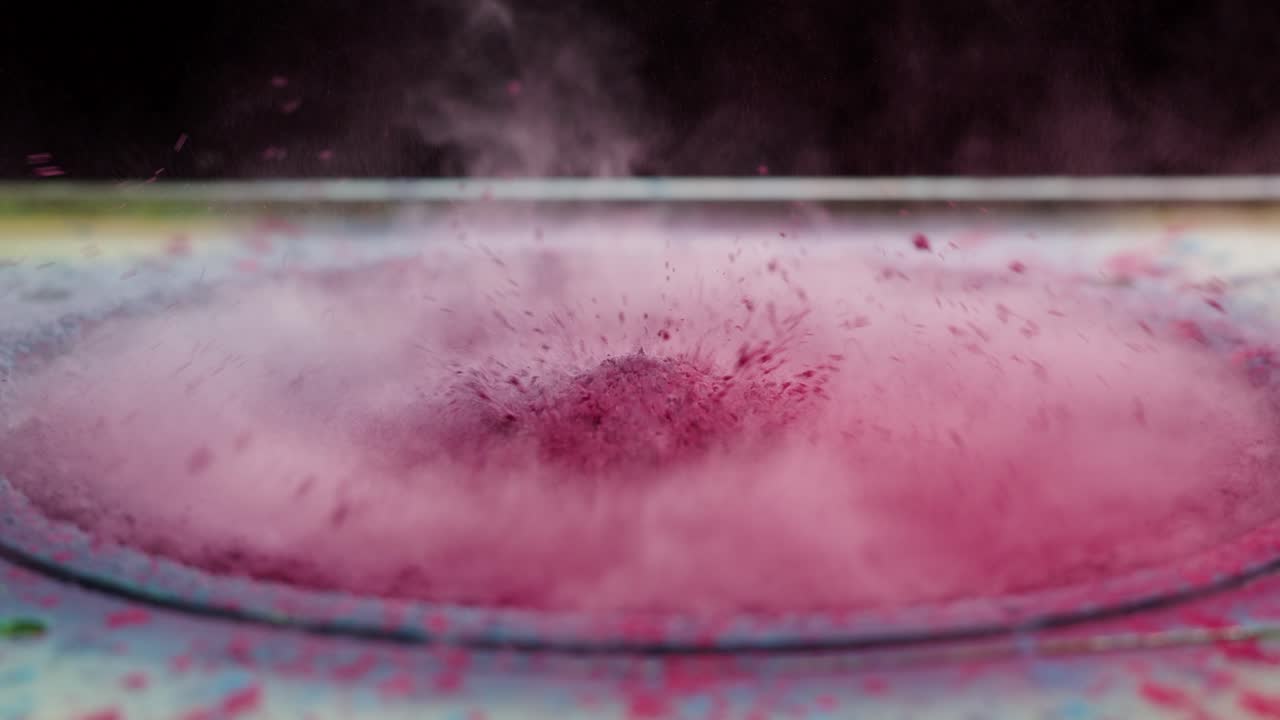 Levende pink pulver eksploderer på en vibrerende højttaler