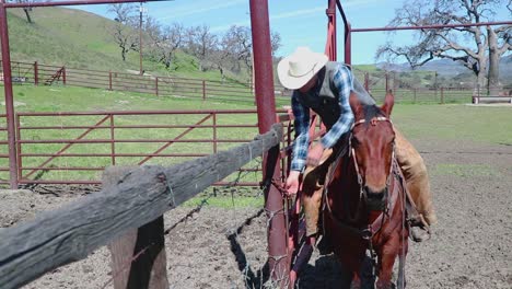 Un-Vaquero-Abre-Una-Puerta-Roja-Para-Comenzar-Su-Duro-Día-De-Trabajo