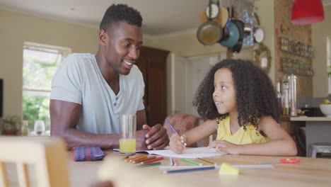 african american father and daughter coloring and giving high five