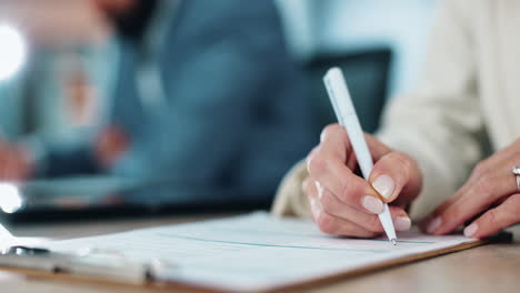 una mujer firmando un documento en un escritorio
