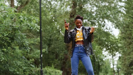 una mujer joven bailando en un parque.