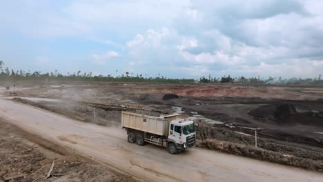 dump trucks driving to the coal mine - coal surface mining site in berau, indonesia