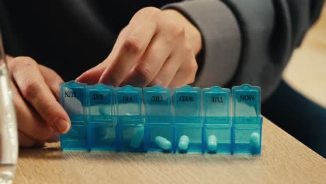 person using a weekly pill organizer