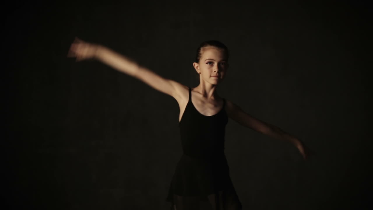 Young ballerina standing on poite in ballet studio