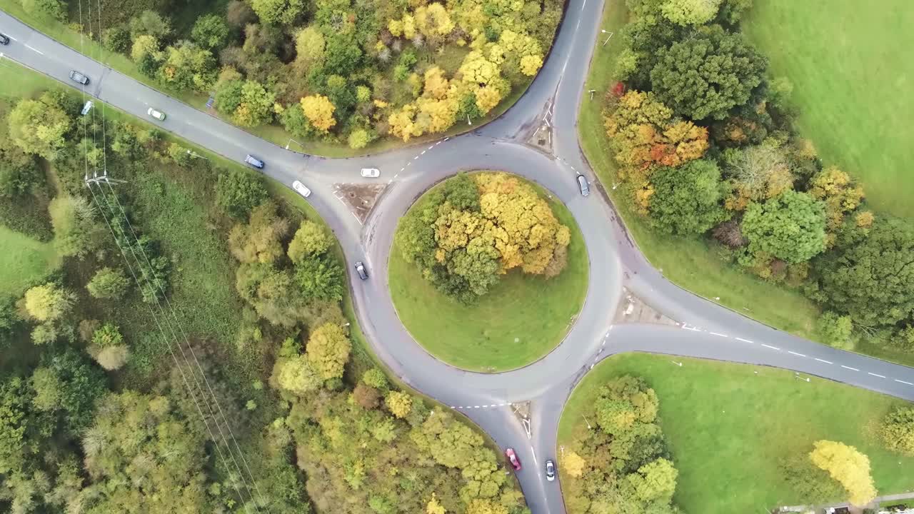 Aerial view rotating over roundabout infrastructure traffic vehicles from above