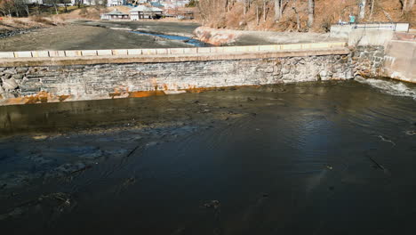 Aerial-pan-across-bottom-section-of-dam-after-reservoir-has-been-drained-of-water