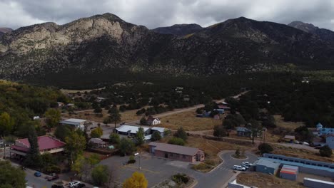 Leaving-cloudy-Colorado-town-at-the-foot-of-the-Rocky-Mountains,-Aerial