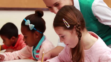 Teacher-helping-her-pupils-during-class