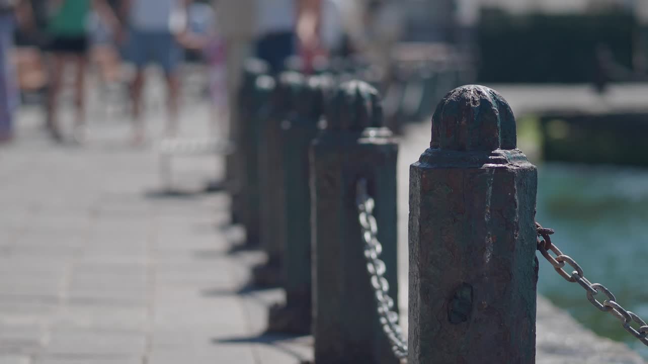 Row of bollards with chain near water