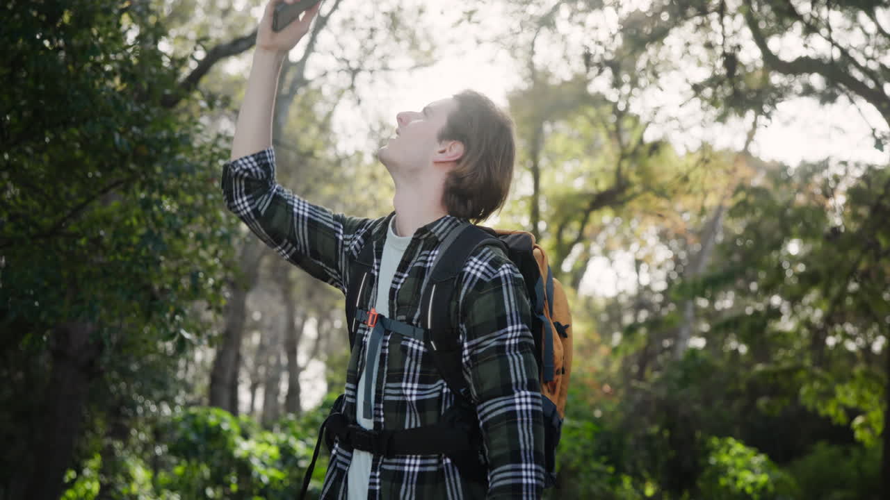 Man trying to get phone signal in the forest
