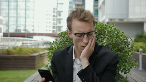 serious man receiving news on phone, looking sad, swiping