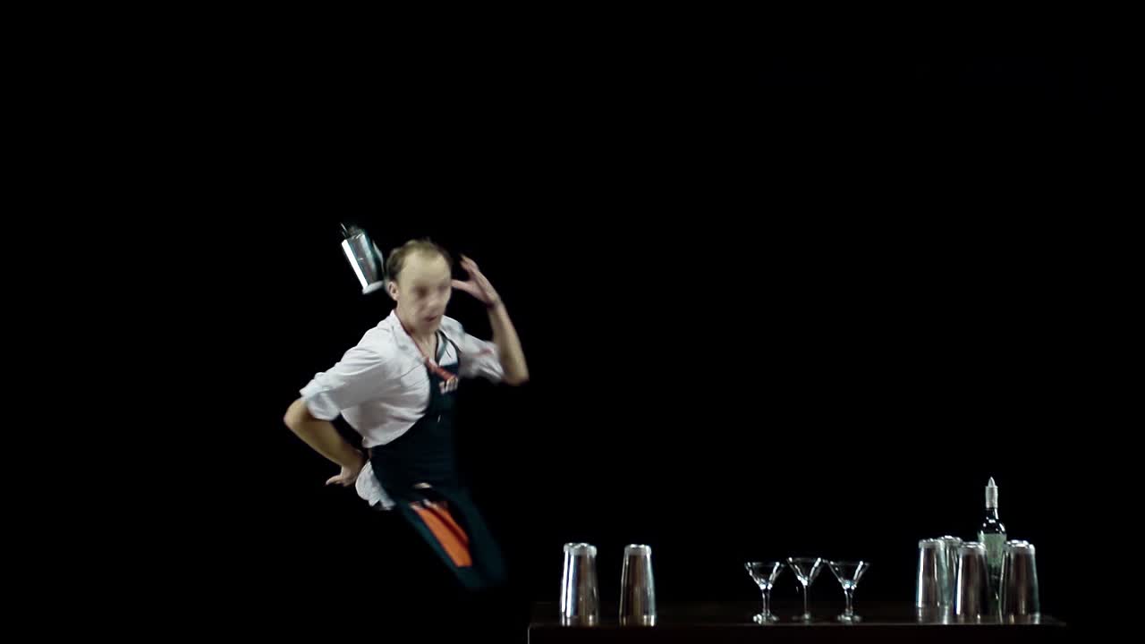 Bartender juggling the objects on black background