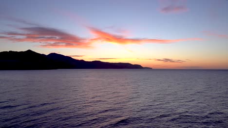 vista tranquila y relajante hacia el océano al atardecer con silueta de montaña en segundo plano
