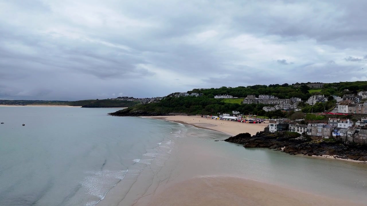 Kinoreifes Luftvideo von St. Ives, das den Hafen, freiliegenden Sand, festgemachte Boote und die malerische Küstenlandschaft entlang der kornischen Küste zeigt