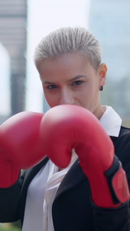determined businesswoman wearing boxing gloves