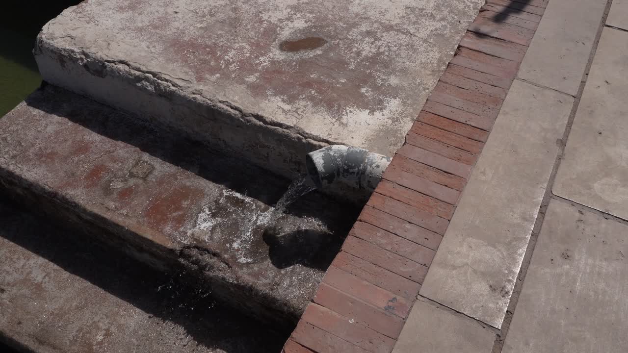 A pipe where water flows continuously over concrete steps