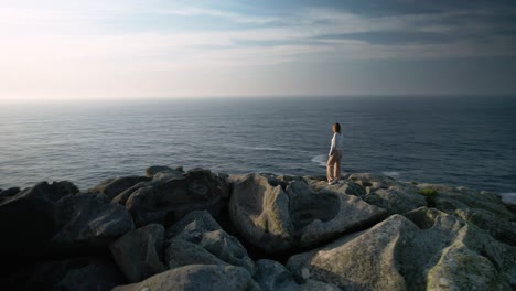 Turista-De-Pie-Sobre-Rocas-A-La-Luz-Del-Sol-En-La-Costa-De-Malpica-En-A-Coruña,-España