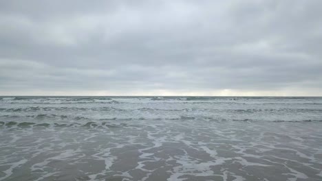 Aerial-drone-view-of-waves-splashing-at-the-shore-of-Olon-beach-in-Ecuador