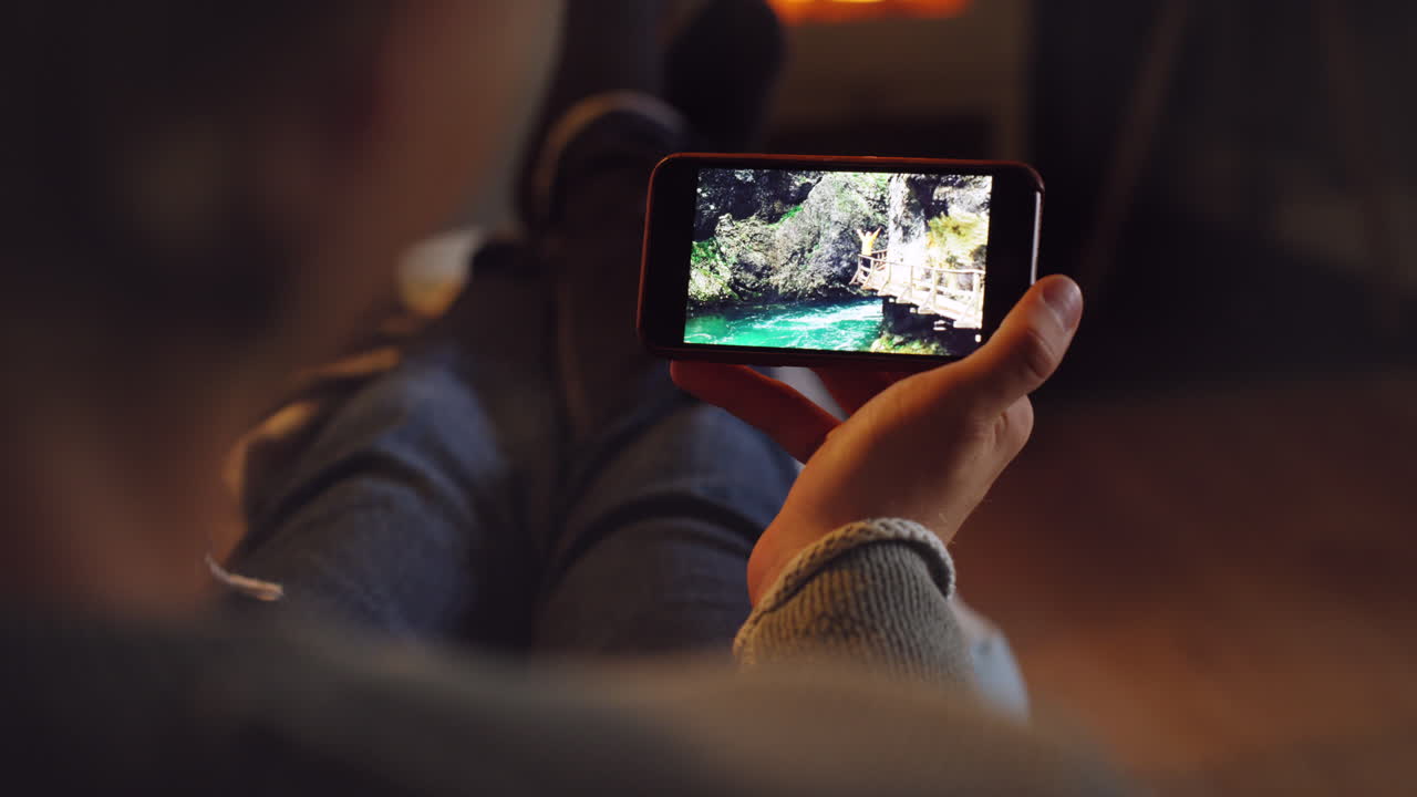 Persona mirando una foto de una cascada en un smartphone