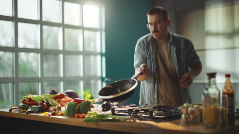 man cooking vegetables in kitchen