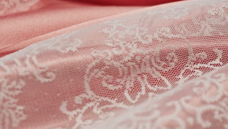 white lace on pink silk close-up, guipure texture and satin luxury cloth background. luxurious design textile. wedding dress