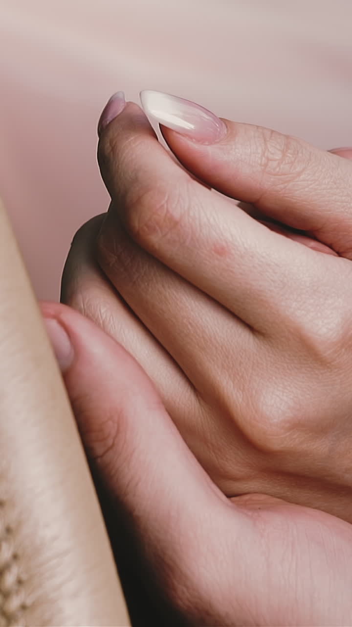 CU, slow motion: young man holds and strokes girlfriend hand near steering wheel wrapped with beige leather in car salon extreme close view
