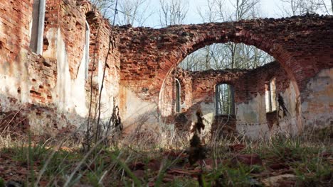 Vista-De-ángulo-Bajo-Con-Hierba-De-Iglesia-Abandonada-Pared-De-Ladrillo-Interior-En-Forma-De-Arco