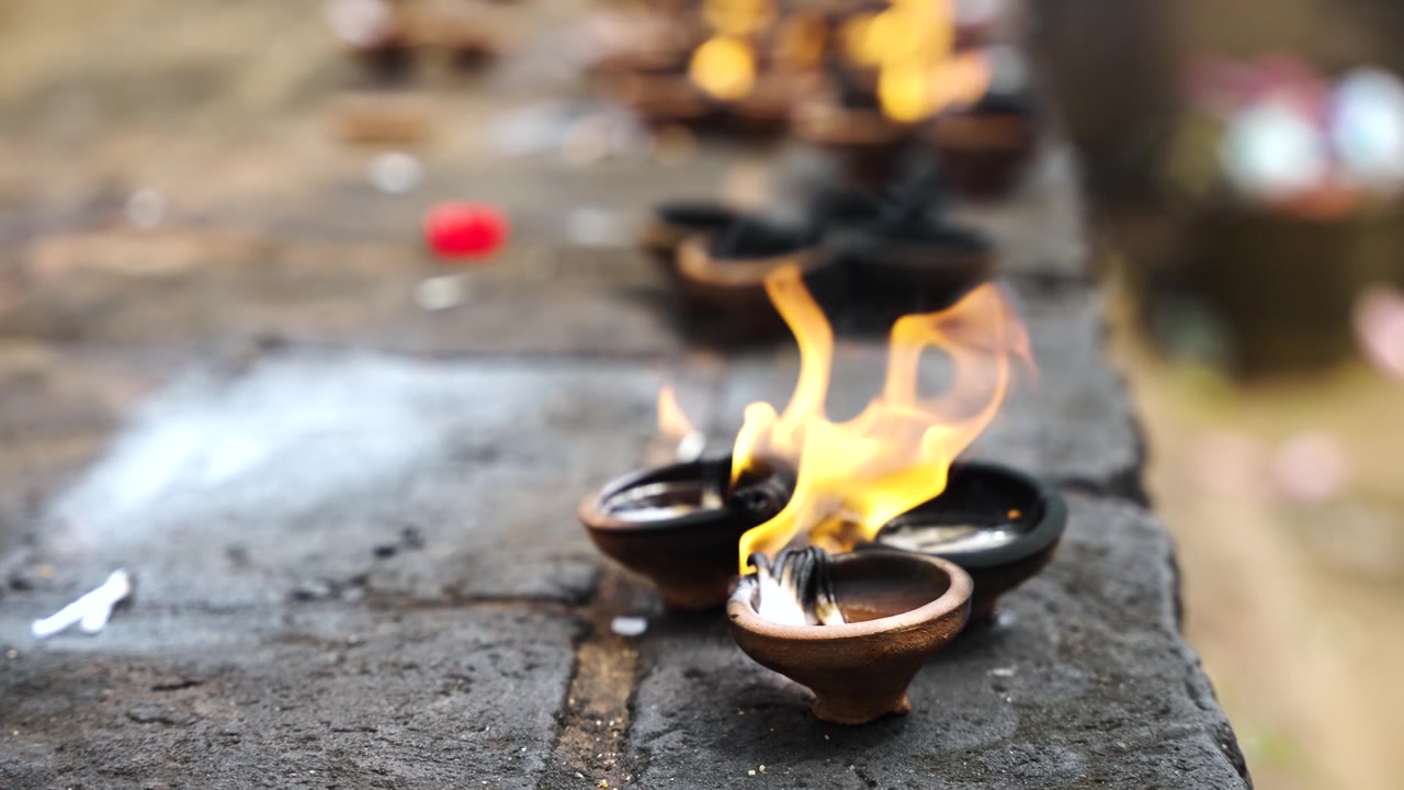 Vista de cerca de varitas de incienso encendidas, llenando el aire con humo aromático y creando una atmósfera serena y espiritual para la meditación y la oración.