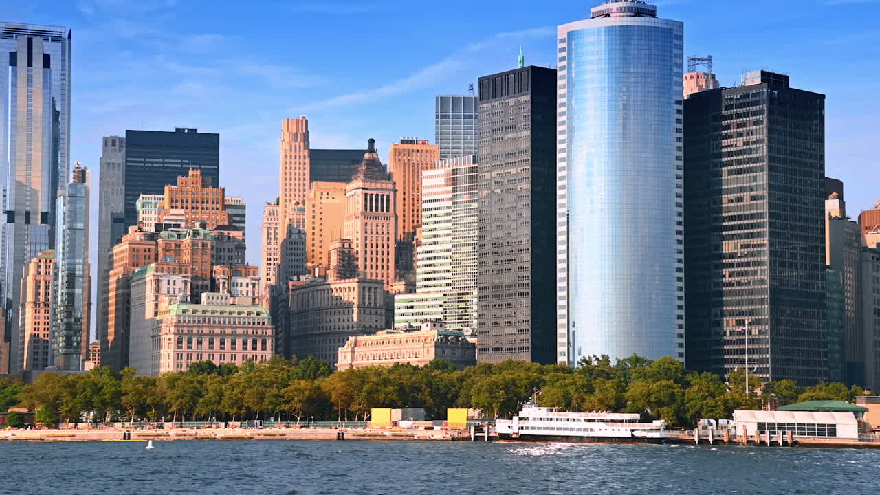 Variegated skyline of modern New York, USA at daytime. Green waterfront of metropolis from the riverscape view