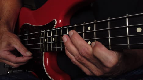 medium close up shot of electric bass playing using right thumb hand