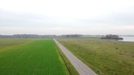 slow drone shot of motorcyclist driving past the camera going down