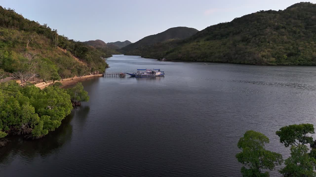 Peaceful bay waters at Sitio Coring, Bay in Western Culion Island, Philippines, with surrounding hills, a docked boat, and dense tropical greenery in a serene island setting