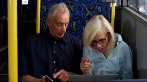 Senior-couple-using-laptop-while-travelling-in-bus-4k