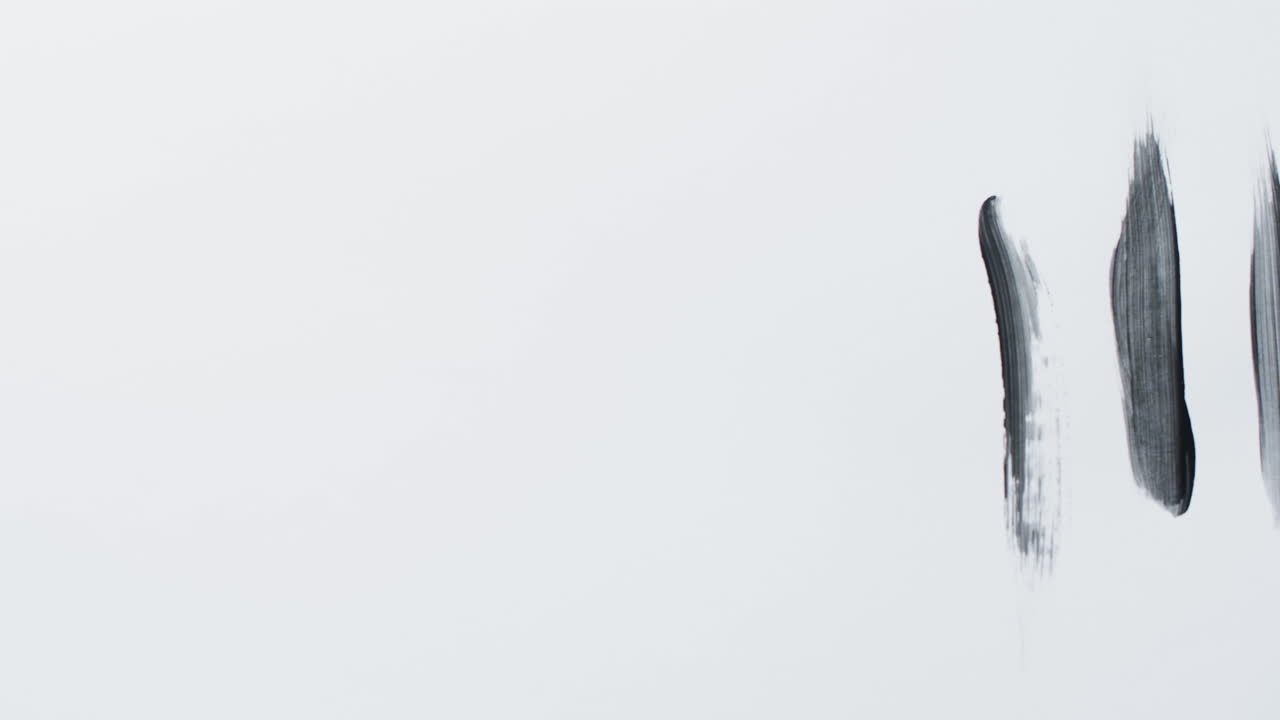 primer plano de rayas de pintura negra sobre fondo blanco con espacio de copia, cámara lenta